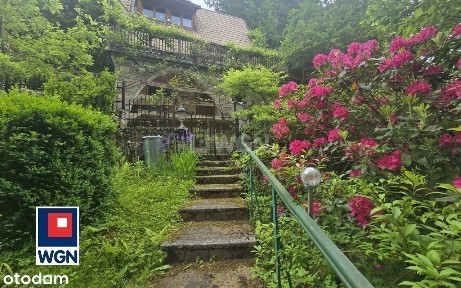 Dom na wzgórzu z widokiem na góry i lasy.