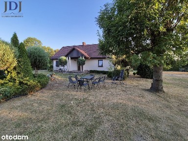 Urokliwy drewniany dom z duszą wśród zieleni.