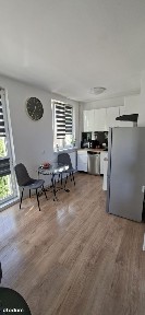 Słoneczna narożna kawalerka w sąsiedztwie łąk i terenów zielonych.