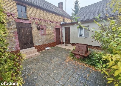 Połowa domu jednorodzinnego z budynkami gospodarczymi i pownicą