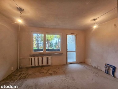 Kawalerka na wysokim parterze w niskim bloku. Duży balkon.