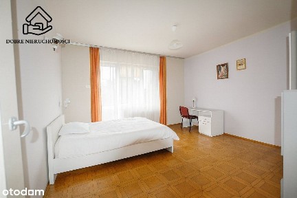 Dom na dużej działce z budynkami gospodarczymi.