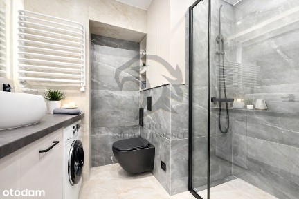 Wiesia w fartuchu w kratę stoi z wałkiem w ręku.