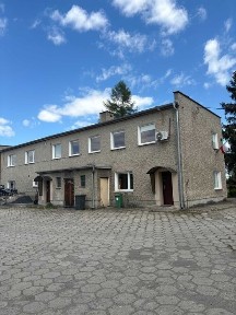 Nieruchomość z budynkiem socjalno-biurowym, terenem zielonym i garażami.