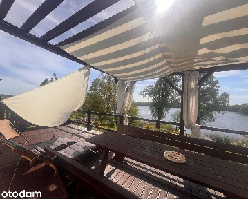 Dom nad jeziorem z linią brzegową, pomostem