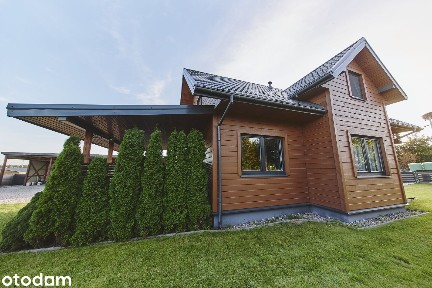Dom do wejścia z tarasem, budynkiem gospodarczym, wiatą na auta