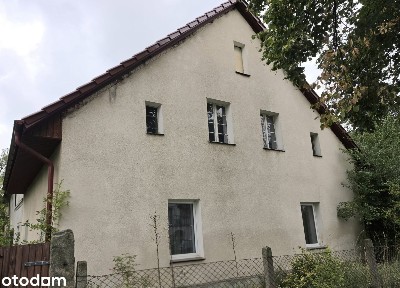 Dom do remontu i zabudowania gospodarcze oraz duży ogród.