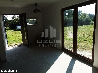 Słoneczna działka pod lasem z drewnianym domkiem